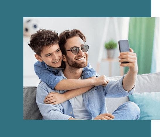 father son taking a picture Dad and son smiling while taking a selfie together in sunglasses from Missouri Eye Consultants