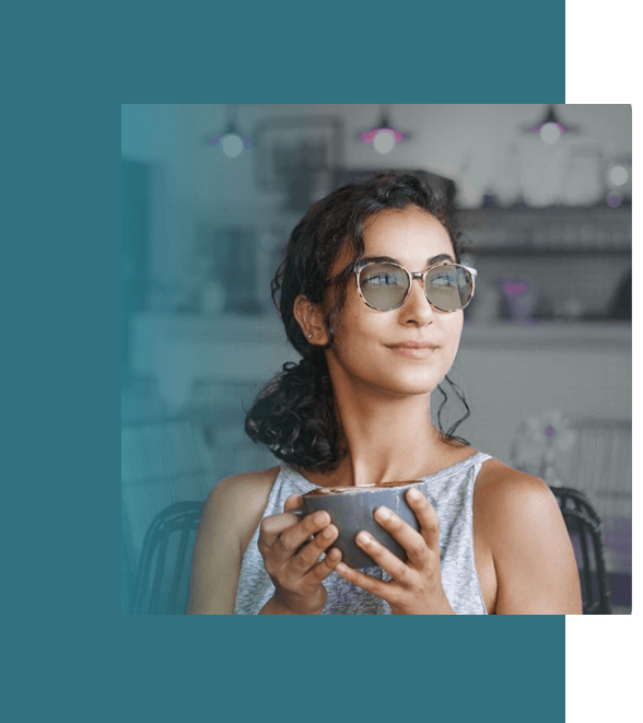clinic-proven Woman enjoying coffee while wearing stylish sunglasses from Missouri Eye Consultants